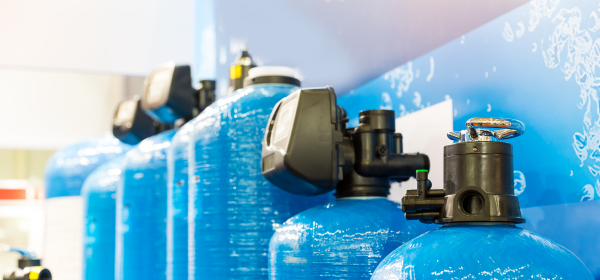Tanques azules de purificación de agua con válvulas y sistemas de filtrado industrial.